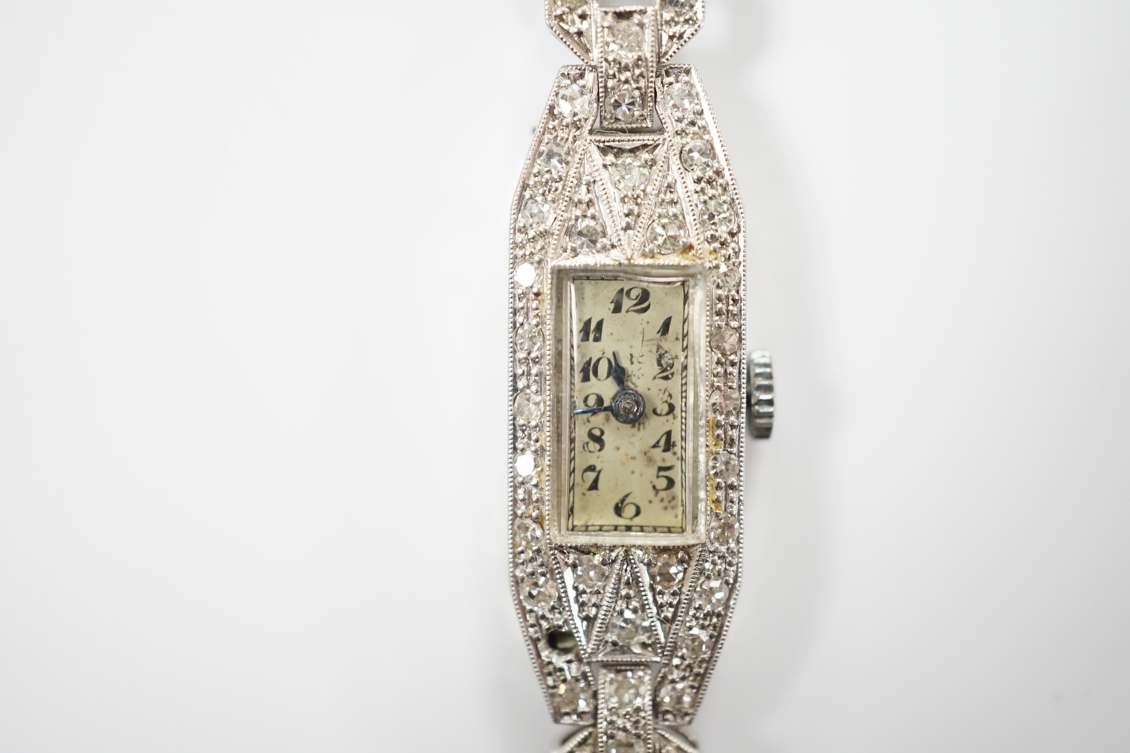 A lady's white metal (engraved platinum) and diamond cluster set manual wind cocktail watch, on a leather strap.
